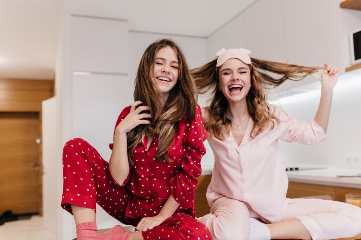 jovens garotas sentadas na cama vestindo pijamas