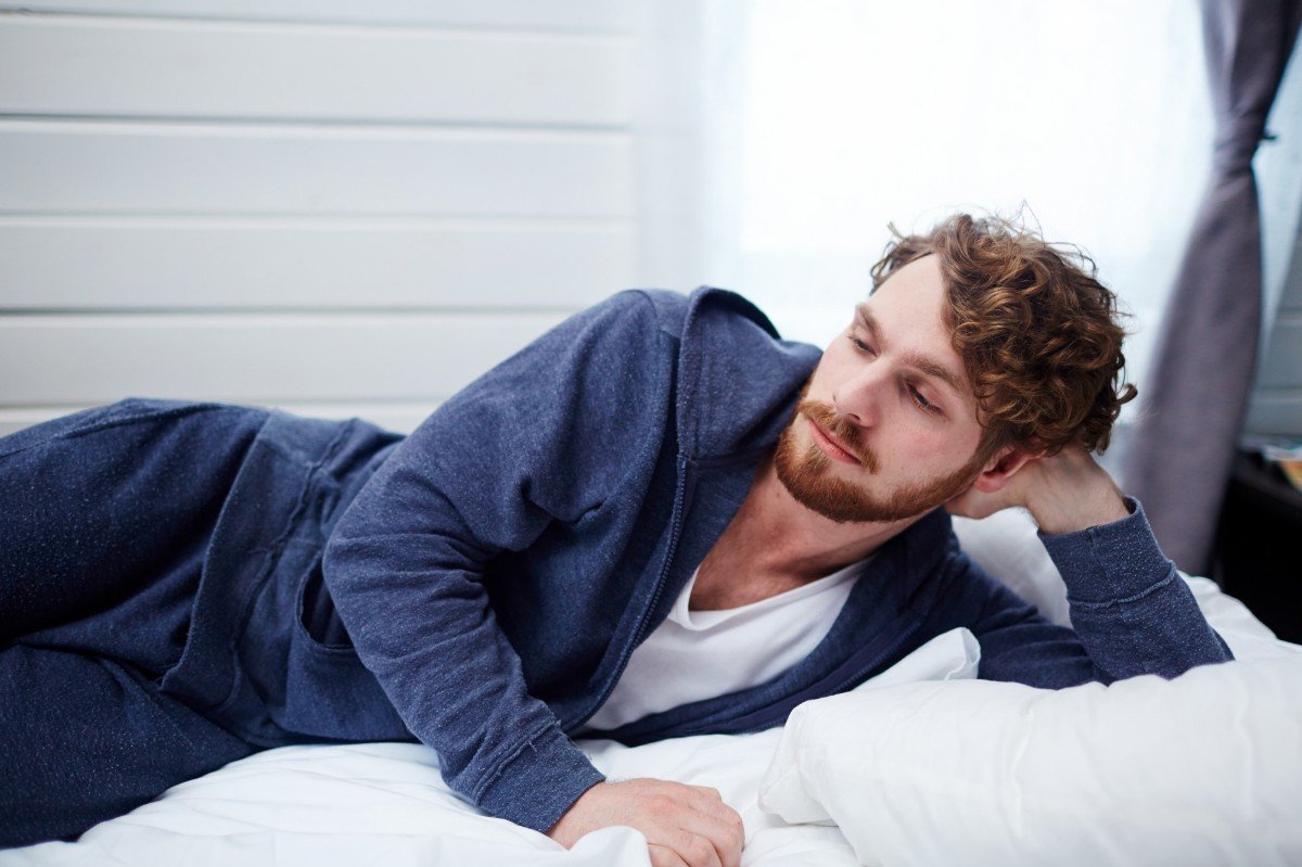 homem com pijama masculino deitado na cama