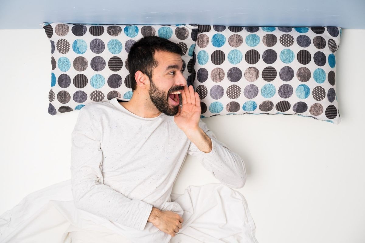 homem deitado em cama de casal usando pijama branco