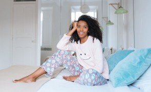 garota sentada na cama com pijamas de inverno