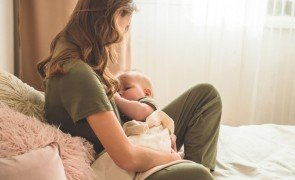 mulher com pijama de amamentação com bebê mamando